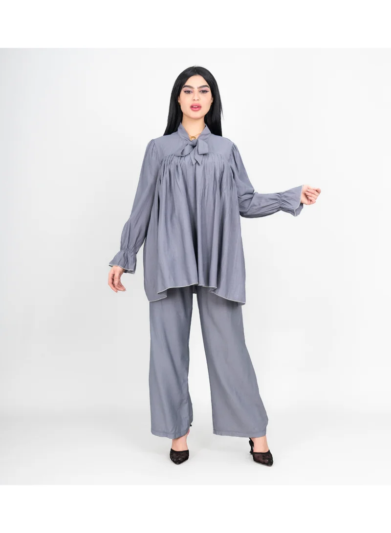 اكسا طقم عصري من قطعتين، بلوزة وبنطال بلون موحد، مزين بفيونكة